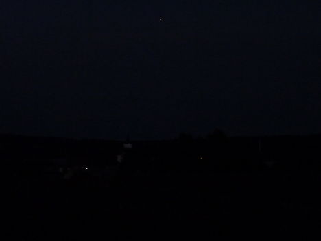 A falu éjszakai látképe a Jupiterrel.