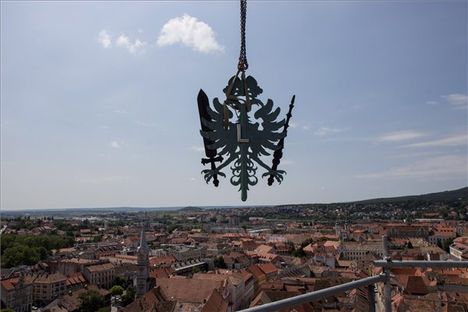 A soproni tűztorony leszerelt csúcsdíszét egy daru ereszti le, a háttérben a város látható