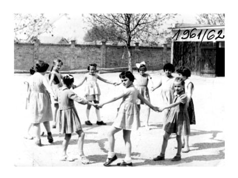 Az akkori negyedikesek "álló" körtáncot járnak a iskola udvarán az óraközi szünetben.