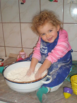 A kett éves, Kovács Noémi kisunokánk, kenyeret dagaszt.