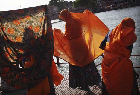 Imájukat befejező asszonyok szárítják ruháikat a Gangesz partján