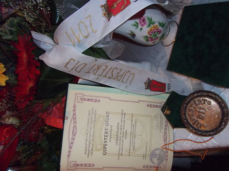 "Újpestért -díj" oklevél, bronz érem, aranygyűrű,a város címerével.